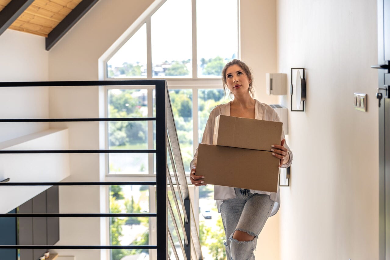 Young woman with boxes by window corridor
